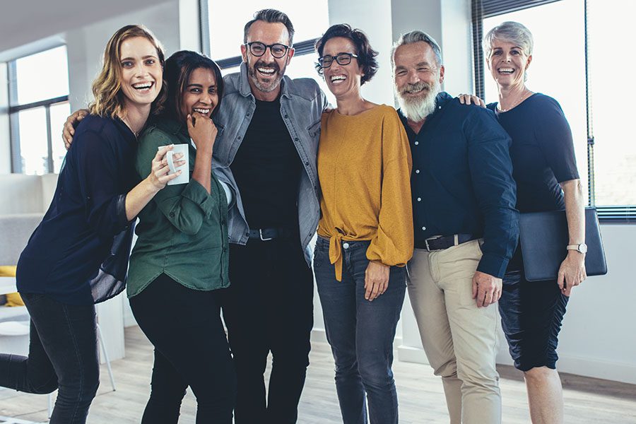 Employee Benefits - Portrait of a Group of Diverse Cheerful Employees Standing in the Office